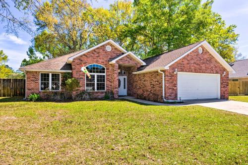 a brick house with a garage in a yard at Ocean Springs Home with Fire Pit and Game Room! in Biloxi