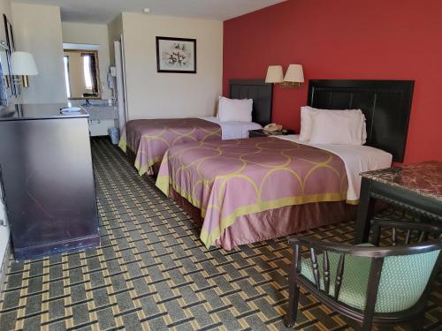 2 camas en una habitación de hotel con paredes rojas en Budget Inn en Texarkana