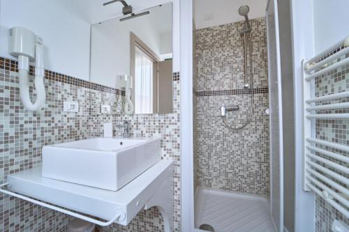 a white bathroom with a sink and a shower at Firmafede Guest House in Sarzana