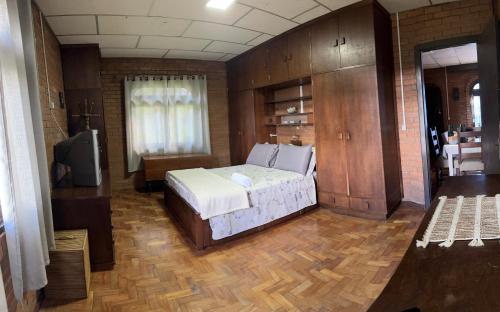 1 dormitorio con 1 cama y TV en Rancho da Vovó Cleia 1, en Gramado