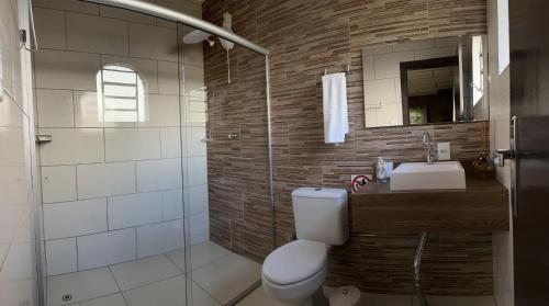 ein Badezimmer mit einem WC, einem Waschbecken und einem Spiegel in der Unterkunft Rancho da Vovó Cleia 1 in Gramado