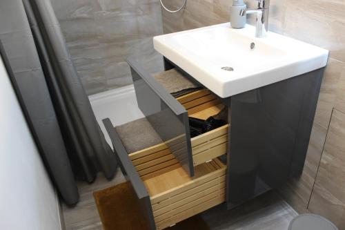 a bathroom with a white sink and a shower at KLEINE SOUTERRAIN WOHNUNG NÄHE HAMBURG in Neu Wulmstorf