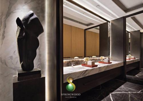 a bathroom with two sinks and a large mirror at Springwood Residence by Tentrem Room in Warungmangga