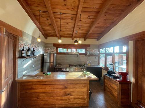 a large kitchen with wooden ceilings and a large island at cabañas Mazzatl jacuzzy in Mazamitla