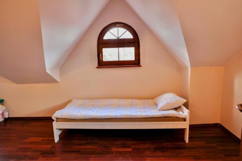 uma cama num quarto com uma janela em Villa Krasnowolska Airport - Self Check-in em Varsóvia