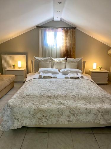 a bedroom with a large white bed with two lamps at Fourka House in Kassandra