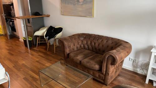 a living room with a brown couch and a glass table at Apartment in München in Munich