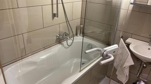 a bathroom with a shower and a tub and a sink at Apartment in München in Munich