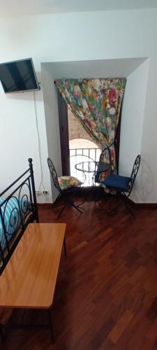 um quarto com uma mesa e cadeiras e uma cortina em Porta Marina em Recanati