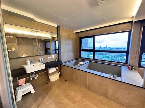 baño con bañera, lavabo y ventana en Spring溫泉 en Toucheng