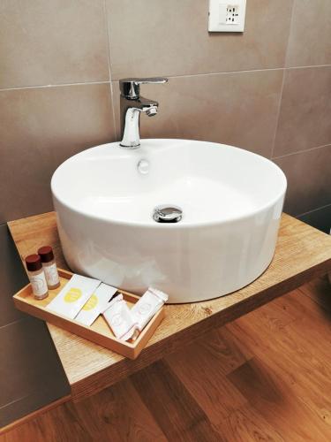 a white sink on a wooden counter in a bathroom at La dimora dei Rolli in Genoa