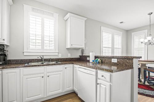 a kitchen with white cabinets and a sink at Cinzia Lane Bungalow in Myrtle Beach