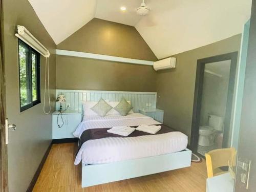 a bedroom with a large bed with white sheets at HaiVen Farm Homestay in Phumĭ Khŭn Réam