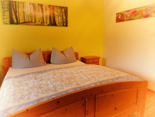 a bedroom with a wooden bed with yellow walls at Siglhof Ferienwohnungen in Aschau im Chiemgau