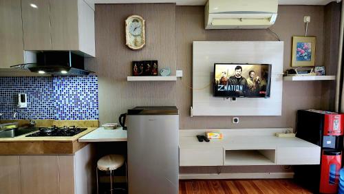 a kitchen with a sink and a tv on the wall at Studio18 Elpis Kemayoran JIEXPO Sunrise View -Min Stay 3 nights- in Jakarta