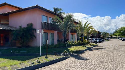 a house with palm trees next to a street at Quinta das Lagoas Residence in Itacimirim