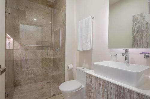 a bathroom with a toilet and a sink and a shower at Apartamento Aldea Zama 7 in Tulum