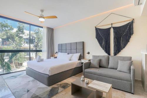 a bedroom with a bed and a couch at Apartamento Aldea Zama 7 in Tulum