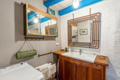 La salle de bains est pourvue d'un lavabo et d'un miroir. dans l'établissement Gîte insolite troglodytique de la Cave des Mouret, à Trôo