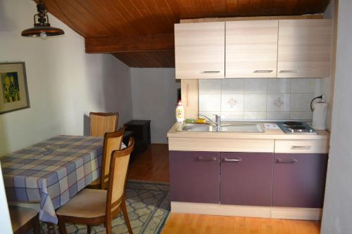a kitchen with a sink and a table with chairs at Apartments by the sea Selce, Crikvenica - 2372 in Selce