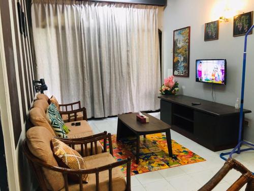 a living room with a couch and a tv at Seri Lagenda Apartment in Kuah