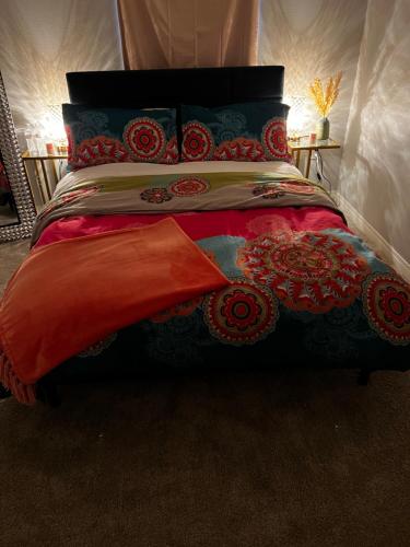 1 cama con edredón rojo y almohadas en Wanda’s pad, en Los Ángeles