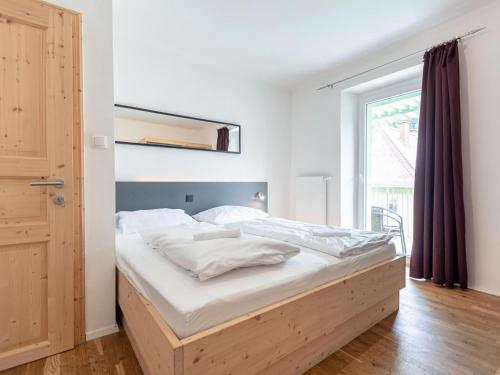 a bedroom with a bed with white sheets and a window at Apartment Seemauer am Erzberg in Eisenerz