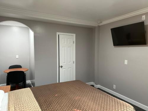 a bedroom with a bed and a flat screen tv at Vegas motel in West Athens