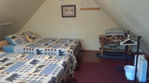 um quarto no sótão com 2 camas e uma cadeira em Alaska's Northland Inn em Trapper Creek