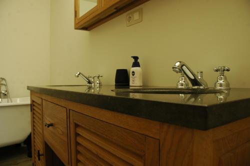 a bathroom counter with a sink and two faucets at Twinkeling Lights in Kluisbergen