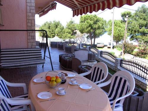 a table with a bowl of fruit on a patio at Family-friendly apartments with swimming pool Kraj, Pasman - 334 in Kraj
