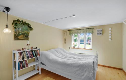 een slaapkamer met een bed en een boekenplank bij 2 Bedroom Amazing Home In Bedsted Thy in Bedsted Thy
