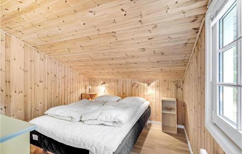 um quarto com uma cama grande numa parede de madeira em Lovely Home In Vejers Strand With Wifi em Vejers Strand