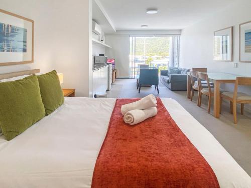 a bedroom with a bed with a towel on it at Blue on Blue Superior Studio Room 1351 in Nelly Bay
