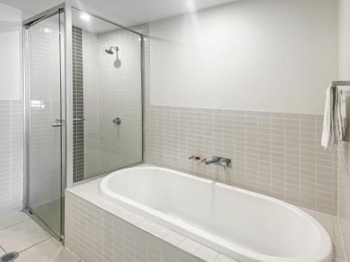 a white bath tub in a bathroom with a shower at Blue on Blue Superior Studio Room 1351 in Nelly Bay