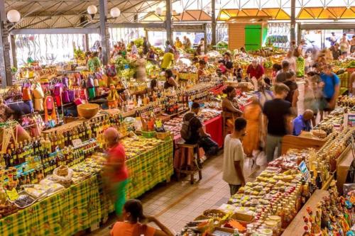 um grupo de pessoas em um mercado com muitas tabelas em Superbe appartement cœur de ville de Fort de France em Fort-de-France