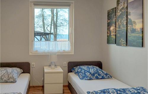 Duas camas num quarto com uma janela em Cozy Home In Wilcze With Lake View em Wilcze