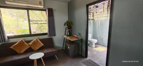 un soggiorno con divano e servizi igienici di Farm Madame Fleur a Petchaburi