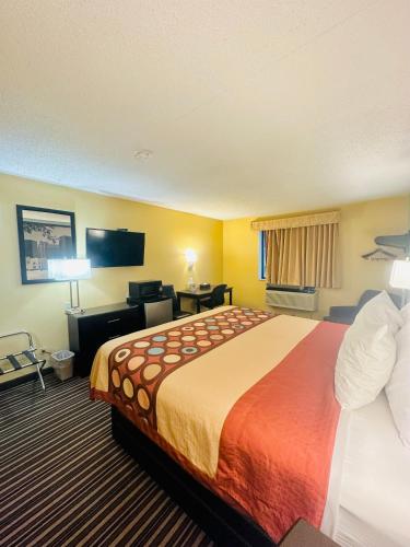a hotel room with a large bed and a television at Super 8 by Wyndham Warrenton in Warrenton