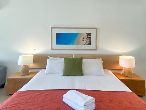 a bedroom with a large bed with two lamps at Blue on Blue Studio Room 1352 in Nelly Bay