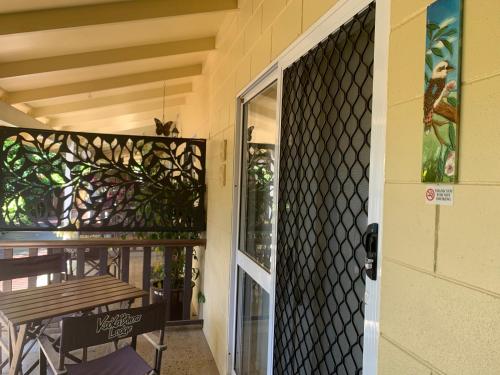 an open door to a patio with a bench on a porch at Kookaburra Motel Yungaburra in Yungaburra