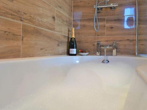 a bottle of wine sitting on top of a bath tub at Puffin House in Belford