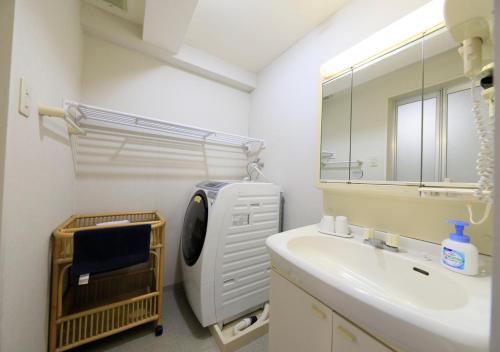 a bathroom with a sink and a washing machine at Katsuura Hilltop Hotel & Residence in Katsuura