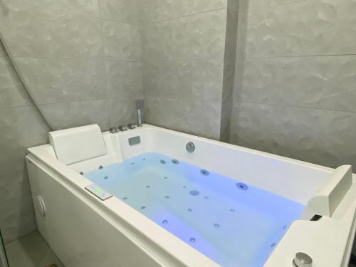 y baño con bañera azul. en Apartasol con jacuzzi SantaFe en Santa Fe de Antioquia