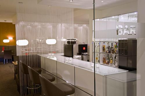 a bar in a restaurant with chairs and bottles of alcohol at Hotel Conti Duisburg - Partner of SORAT Hotels in Duisburg