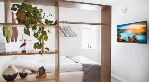 a bedroom with a bed and a window with a plant at Island Apartments in Reykjavík