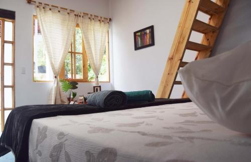 ein Schlafzimmer mit einem Bett in einem Zimmer mit Fenstern in der Unterkunft Bosque Colibrí in Cali