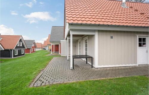 a house with a bench next to a house with a grass yard at 4 Bedroom Awesome Home In Gråsten in Gråsten