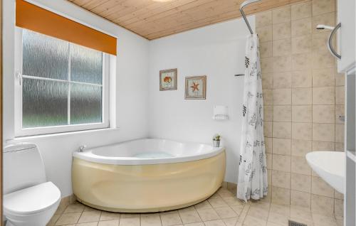 een witte badkamer met een bad en een toilet bij 4 Bedroom Awesome Home In Grsten in Gråsten