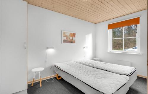 een witte slaapkamer met een bed en een raam bij 4 Bedroom Awesome Home In Grsten in Gråsten